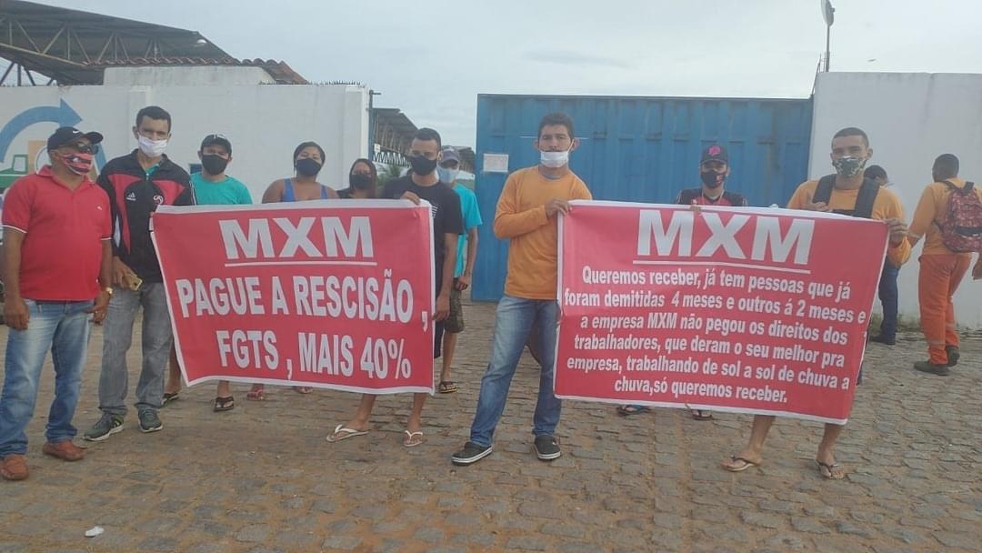 Funcionários da limpeza pública protestam em frente à sede da MXM, em Juazeiro do Norte